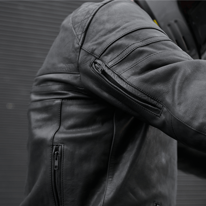Close-up of a black leather jacket with zippers on a dark background